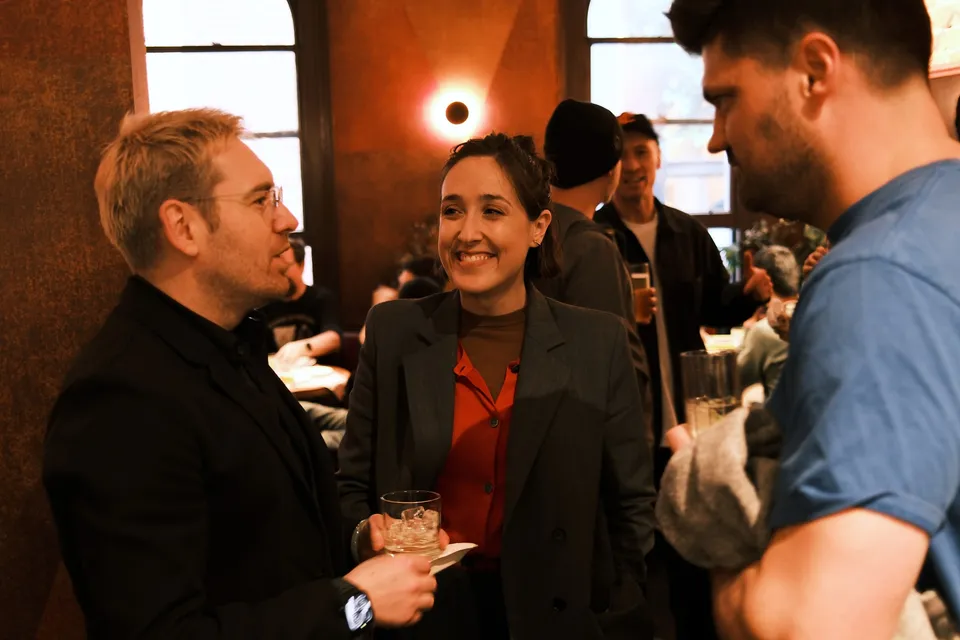 Three guests sharing a conversation over drinks at AI Ops 008
